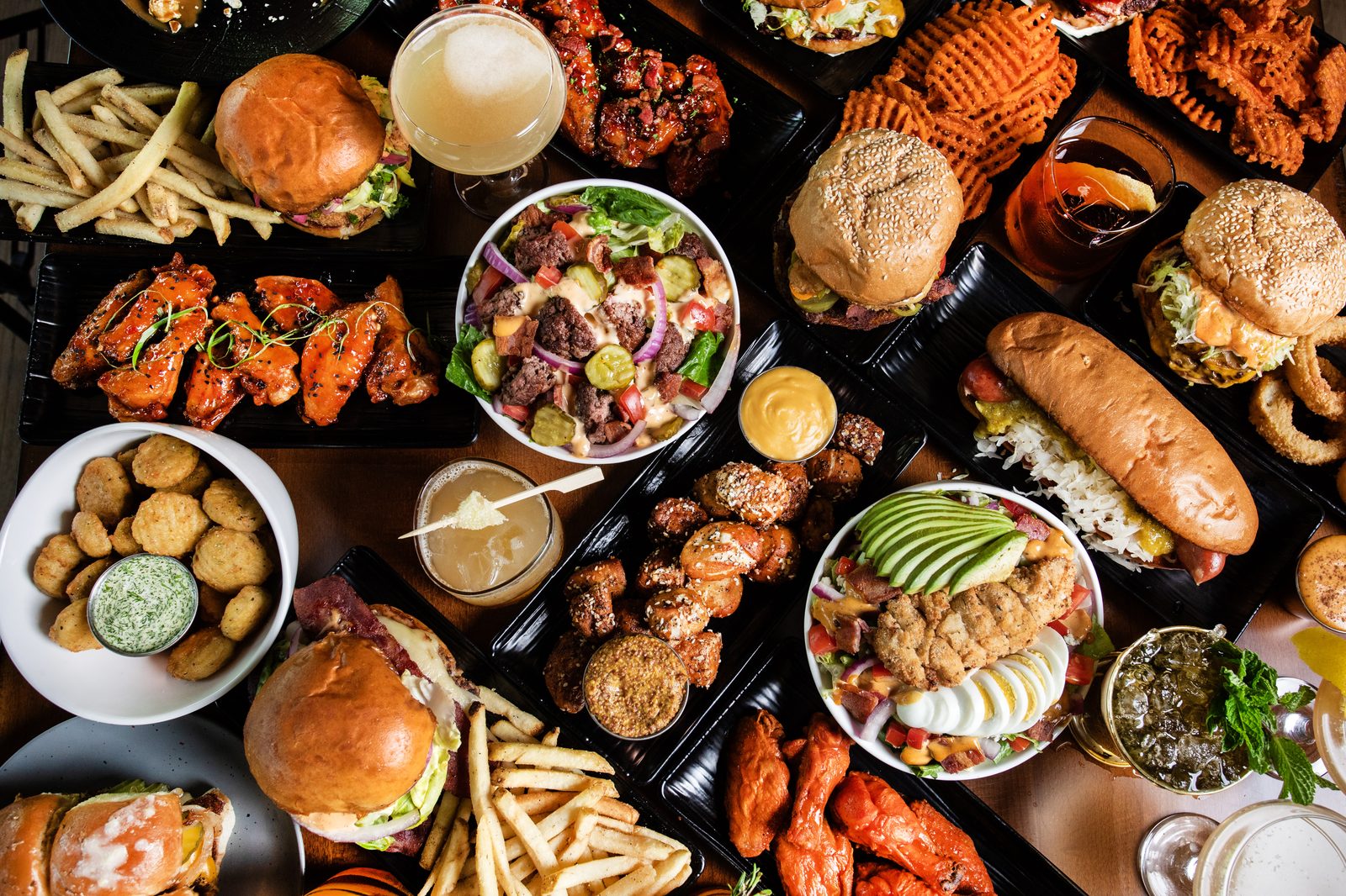 An overhead spread of Ground Rules dishes — burgers, wings, sides and shareables.
